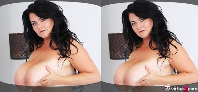 Brunette model Busty Reny displays large breasts in a solo VR scene, presented in 4K resolution with 60 FPS smoothness.