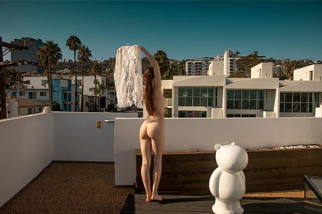 Emily Bloom poses in a window display during this 4K European solo VR video featuring big tits and 60 FPS passthrough visuals.