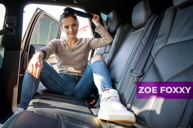 Zoe Foxxy performs oral sex on a partner in the backseat of a car during a VRStars 4K outdoor scene.