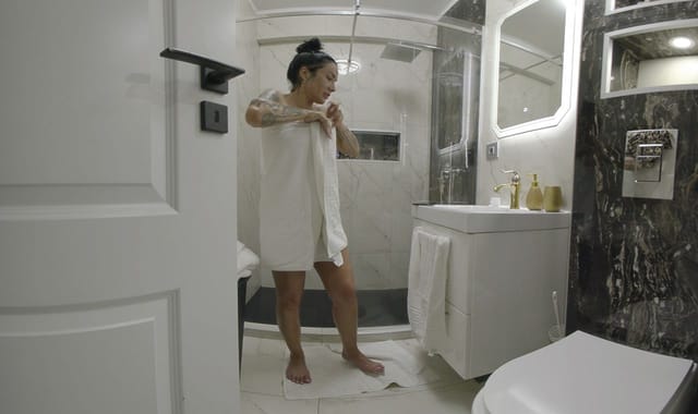 Mistress Kennya poses in a shower during a BDSM vacation fantasy filmed in 4K 60 FPS POV VR.