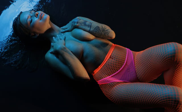 Irina Wind poses in a neon-lit room during a solo softcore VR POV scene rendered in 4K resolution for this premium production.