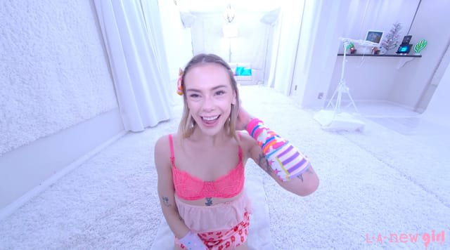 Blonde model Dylan Moore strips in a white studio during a solo casting VR POV video.